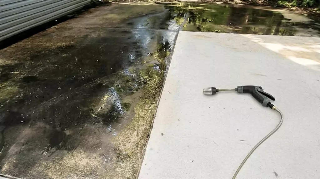 Test Jetterix su una stretta striscia di cemento con anni di accumulo di alghe — striscia chiaramente pulita attraverso la zona sporca